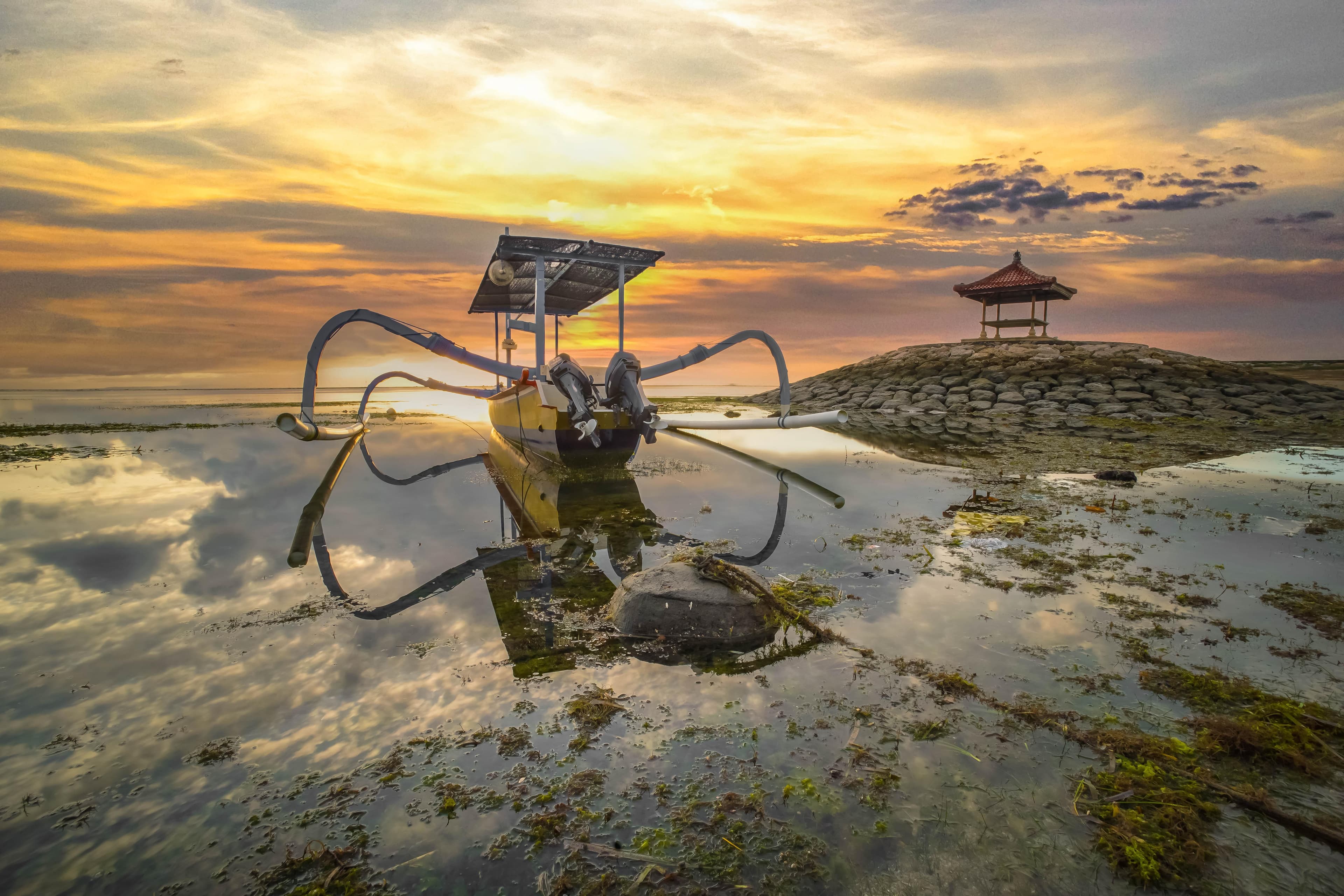 Traditional jukung fishing boat at sunrise on Sanur Beach, Bali